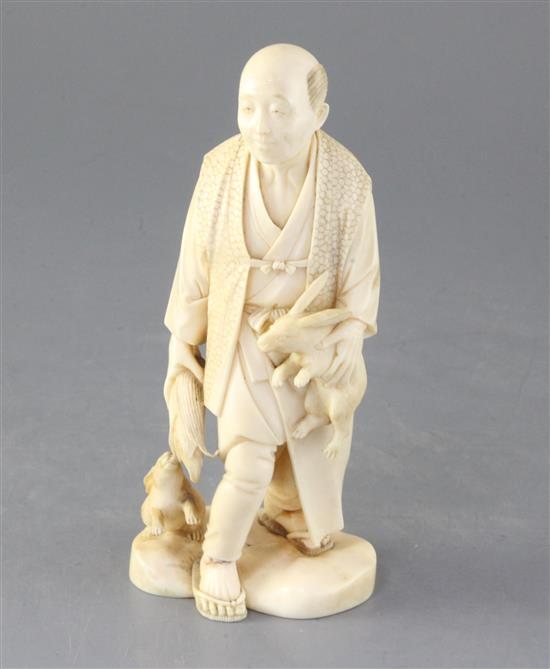 A Japanese ivory okimono of a farmer and two rabbits, early 20th century, height 16.5cm, repairs